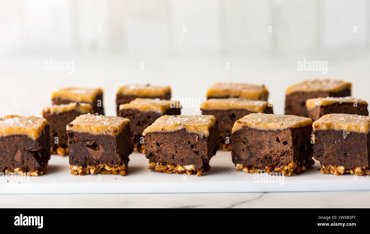 Reihen von Brezelboden gesalzenen Karamell Brownies vor hellem Hintergrund. Stockfoto