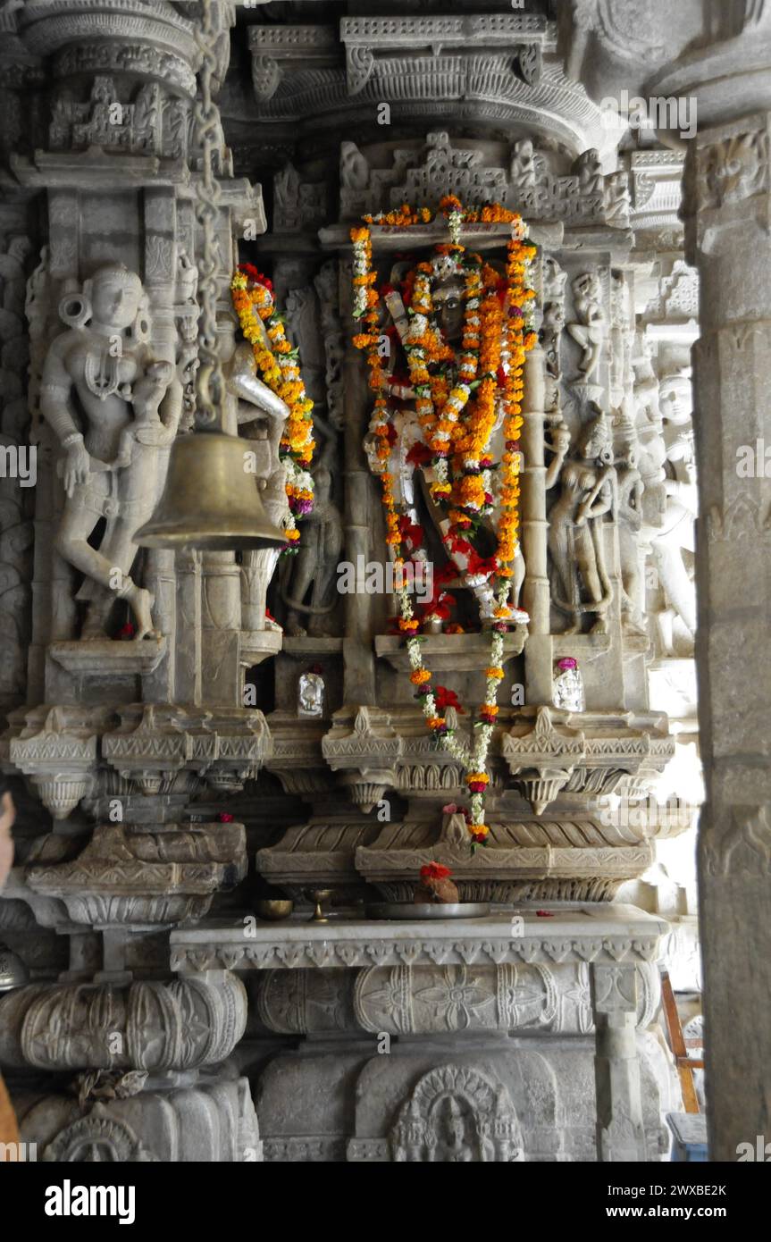 Details, Ranakpur Tempel, Ranakpur, Rajasthan, Ein reich geschmückter Tempelaltar mit Skulpturen und Blumendekorationen, Rajasthan, Nordindien, Indien Stockfoto