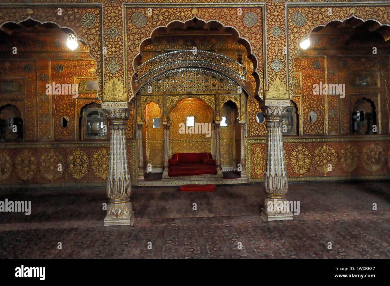 Opulent dekoriertes Interieur mit Säulen und rotem Thron, Jaipur, Rajasthan, Indien Stockfoto