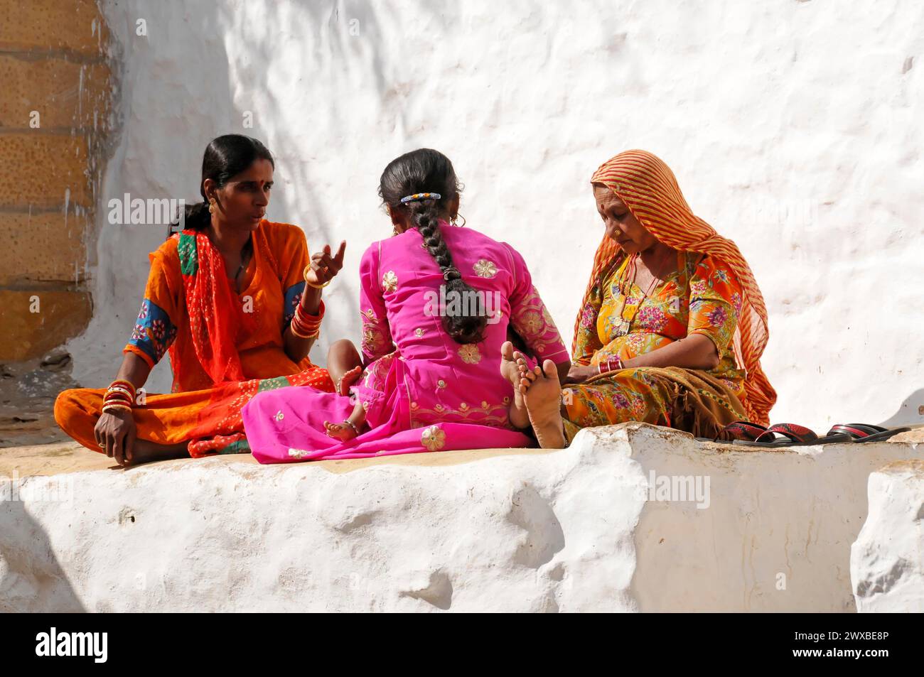 Drei Frauen in farbenfrohen Saris sitzen und reden, Jaipur, Rajasthan, Indien Stockfoto