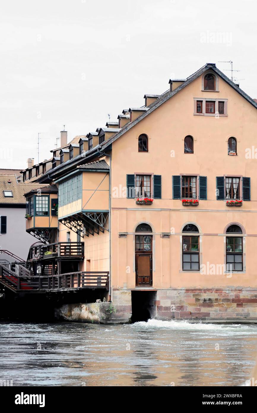 Bootsfahrt auf der L'ILL, Straßburg, Elsass, Eine farbenfrohe Hausfassade mit Blumen auf dem Wasser, in der Nähe einer Holzbrücke, Straßburg, Elsass, Frankreich Stockfoto