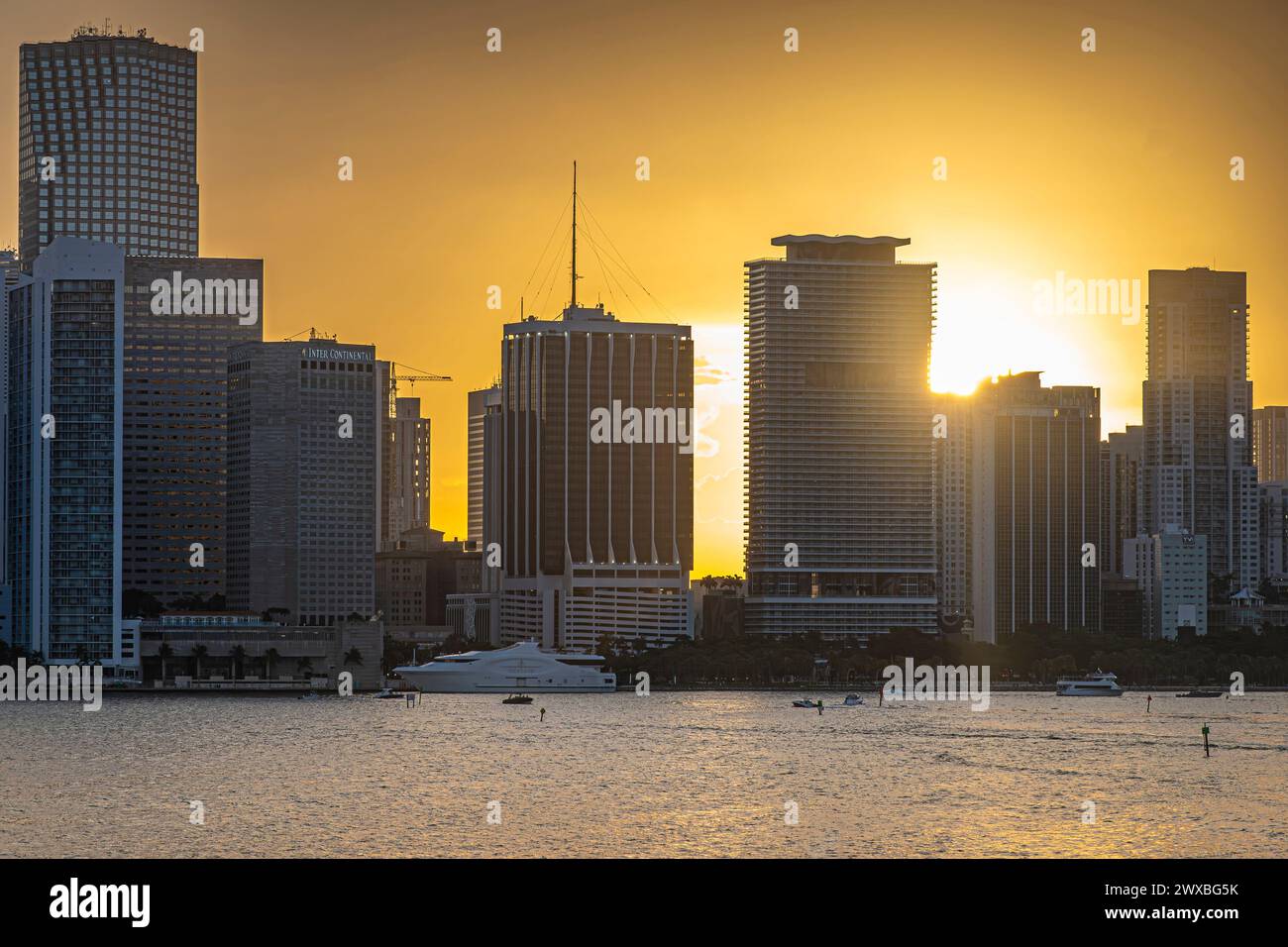 Miami, Florida, USA - 29. Juli 2023: Sonne auf ebenerdiger Ebene hinter Biscayne blvd 3 of 6, hohe moderne Gebäude bilden eine Linie hinter Bayfront Park und Bucht mit y Stockfoto