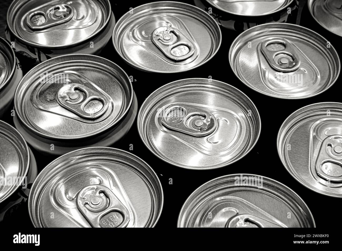 Viele Alu-Limonade oder Bierdosen als Hintergrund. Schwarzweißbild. Selektiver Fokus. Stockfoto