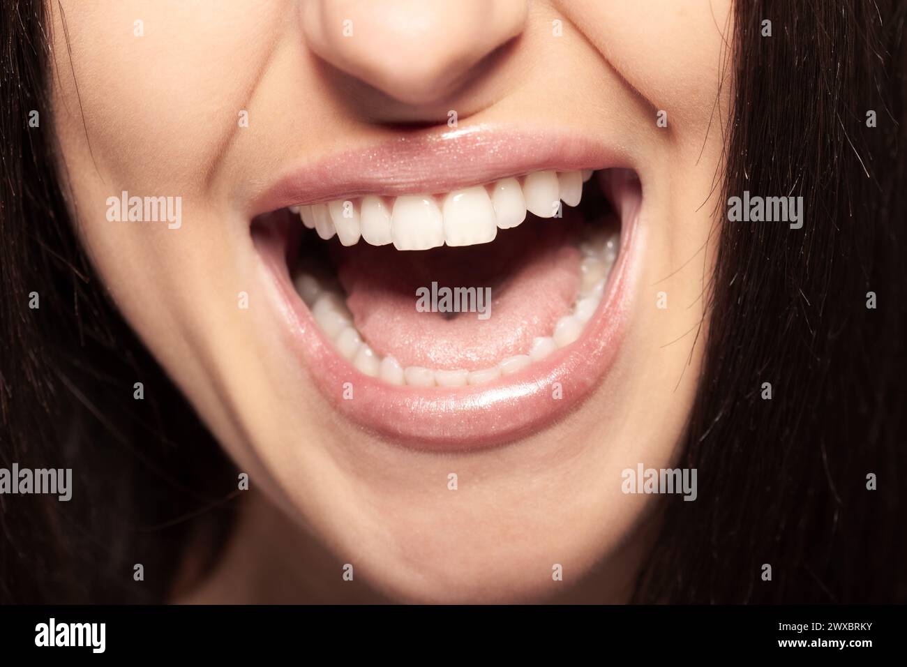 Detaillierte Ansicht einer Frau mit offenem Mund, die ihre Zähne zeigt. Mädchen, die reden, schreien oder singen. Stockfoto