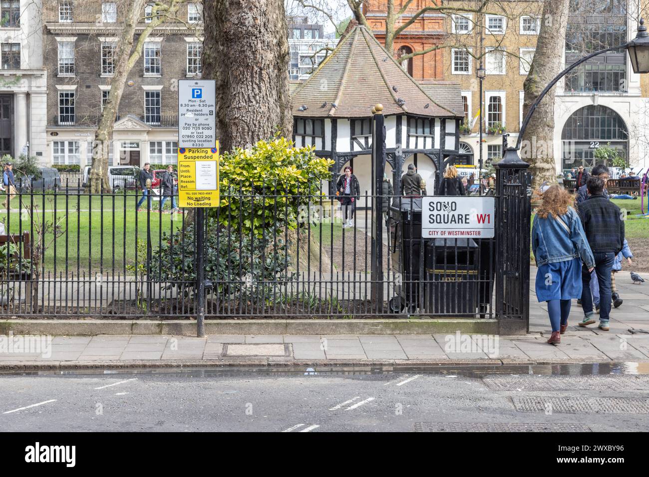 Soho Square Gardens, das nachgeahmte Tudor-Gebäude in seiner Mitte ist eines der vielen denkmalgeschützten Gebäude am Soho Square, einem Drehkreuz der Medienindustrie. Stockfoto
