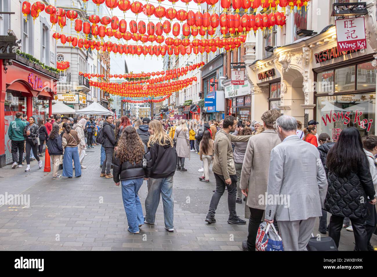 Wardour Street in Chinatown, London, voller Menschenmassen von Einkäufern und Touristen. Menschen, die unter chinesischen Laternen in Londons Chinatown spazieren. Stockfoto
