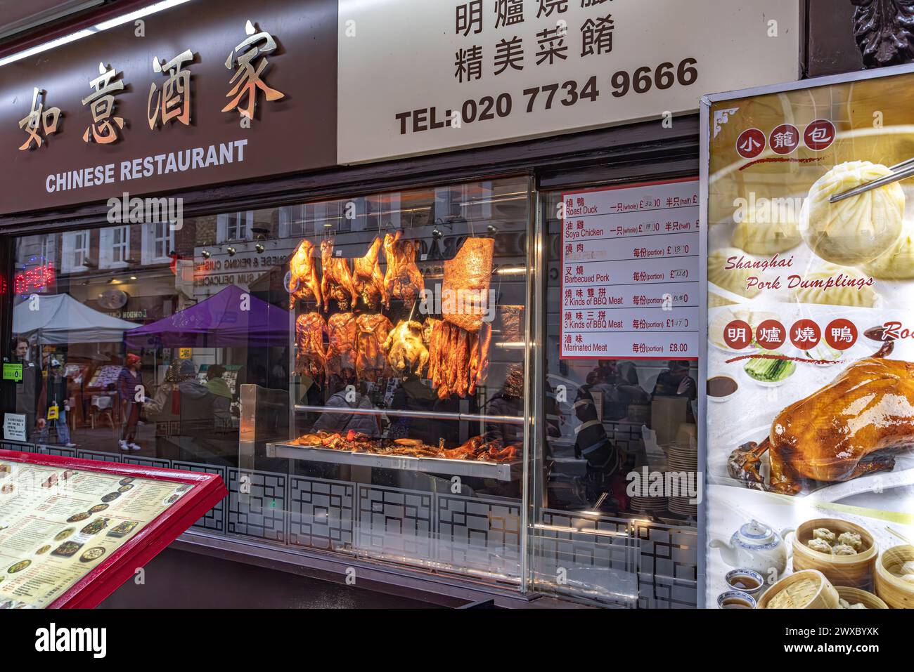 Außenansicht eines chinesischen Restaurants in Chinatown, London. Leckeres, gekochtes Fleisch im Fenster. Stockfoto