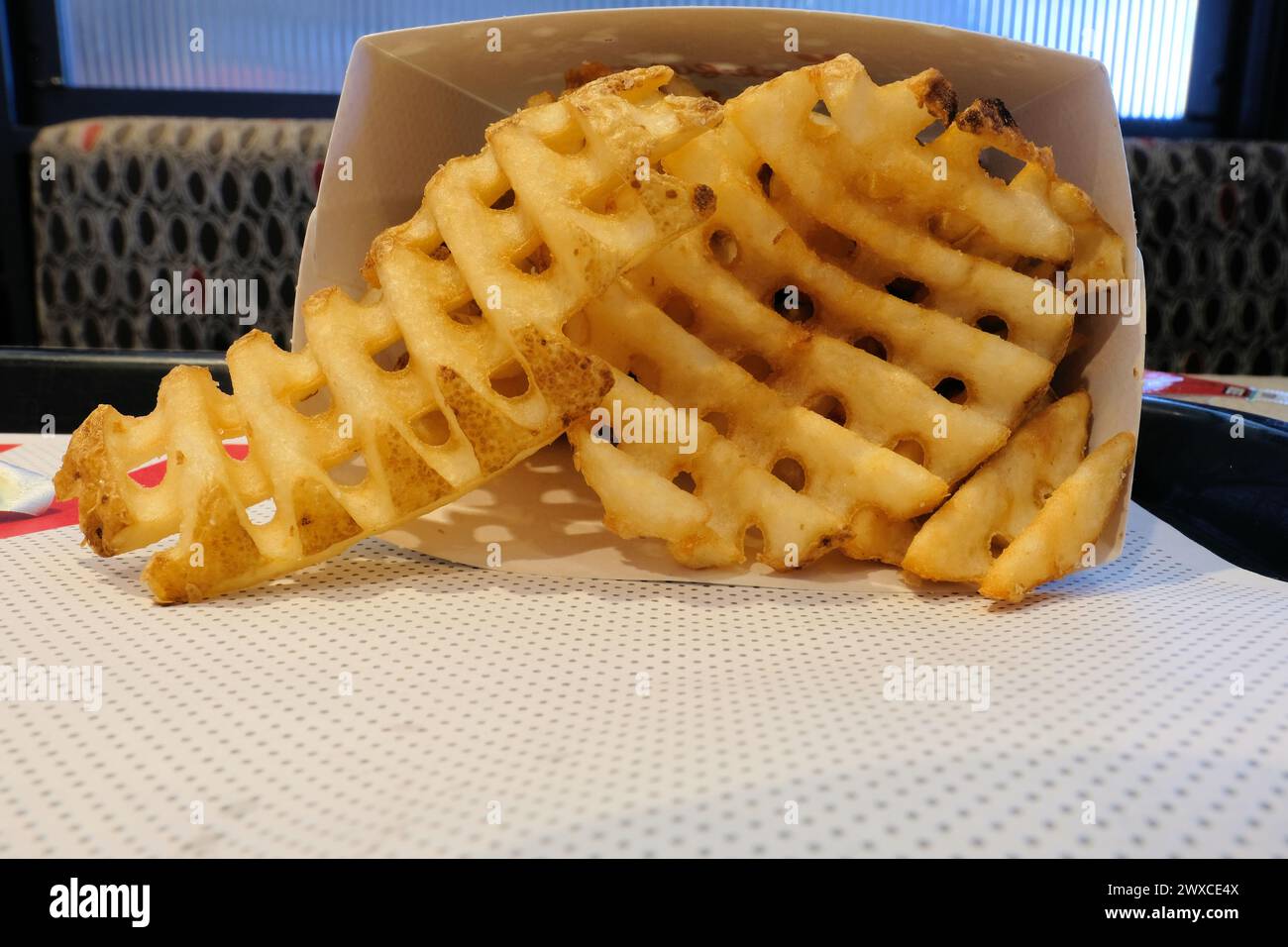 Nahaufnahme von knusprigen goldbraunen Waffelfritten, Crisscut- oder Criss-Crosscut-Pommes; eine Variante von Pommes Frites, die in Fast-Food-Restaurants serviert werden. Stockfoto