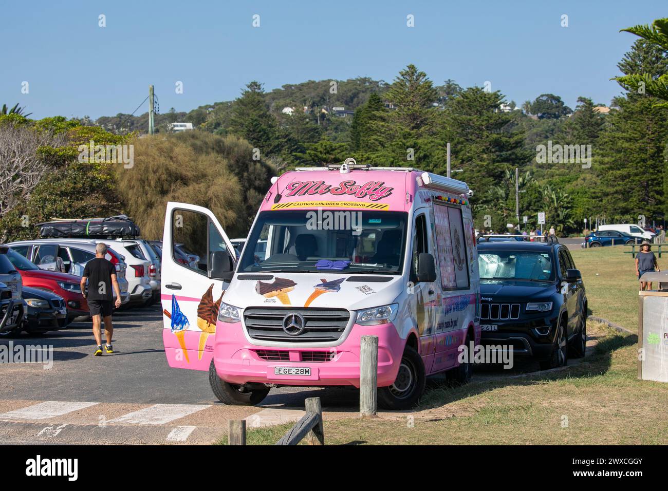Mr Softy Eisverkäufer, der vom traditionellen Eiswagen in Pink, Palm Beach, Sydney, Australien während des heißen osterwochenendes 2024 fährt Stockfoto