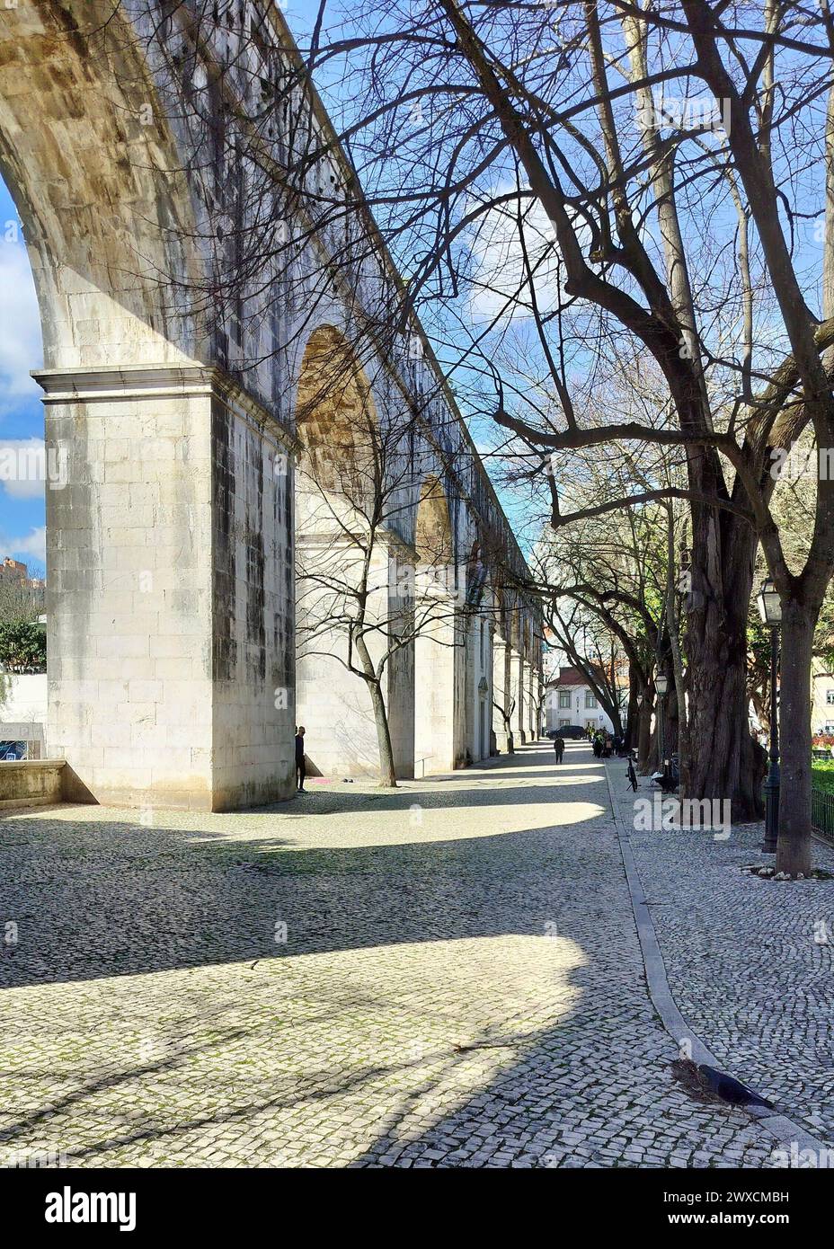 Steinbögen von Amoreiras Abschnitt des Aquädukts Aguas Livres, Kopfsteinpflasterweg im Garten Amoreiras bei Sonnenuntergang Licht und Schatten, Lissabon, Portugal Stockfoto