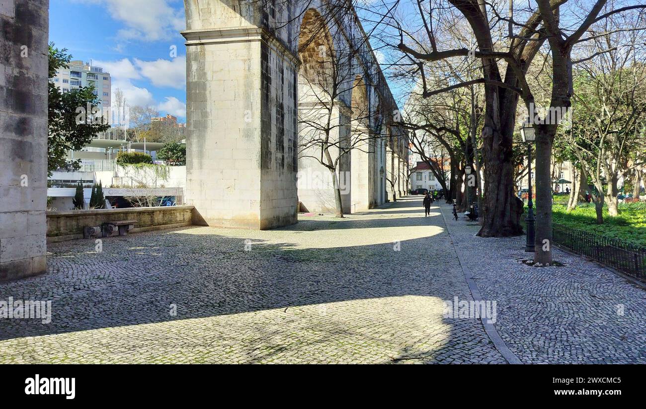 Steinbögen von Amoreiras Abschnitt des Aquädukts Aguas Livres, Kopfsteinpflasterweg im Garten Amoreiras bei Sonnenuntergang Licht und Schatten, Lissabon, Portugal Stockfoto