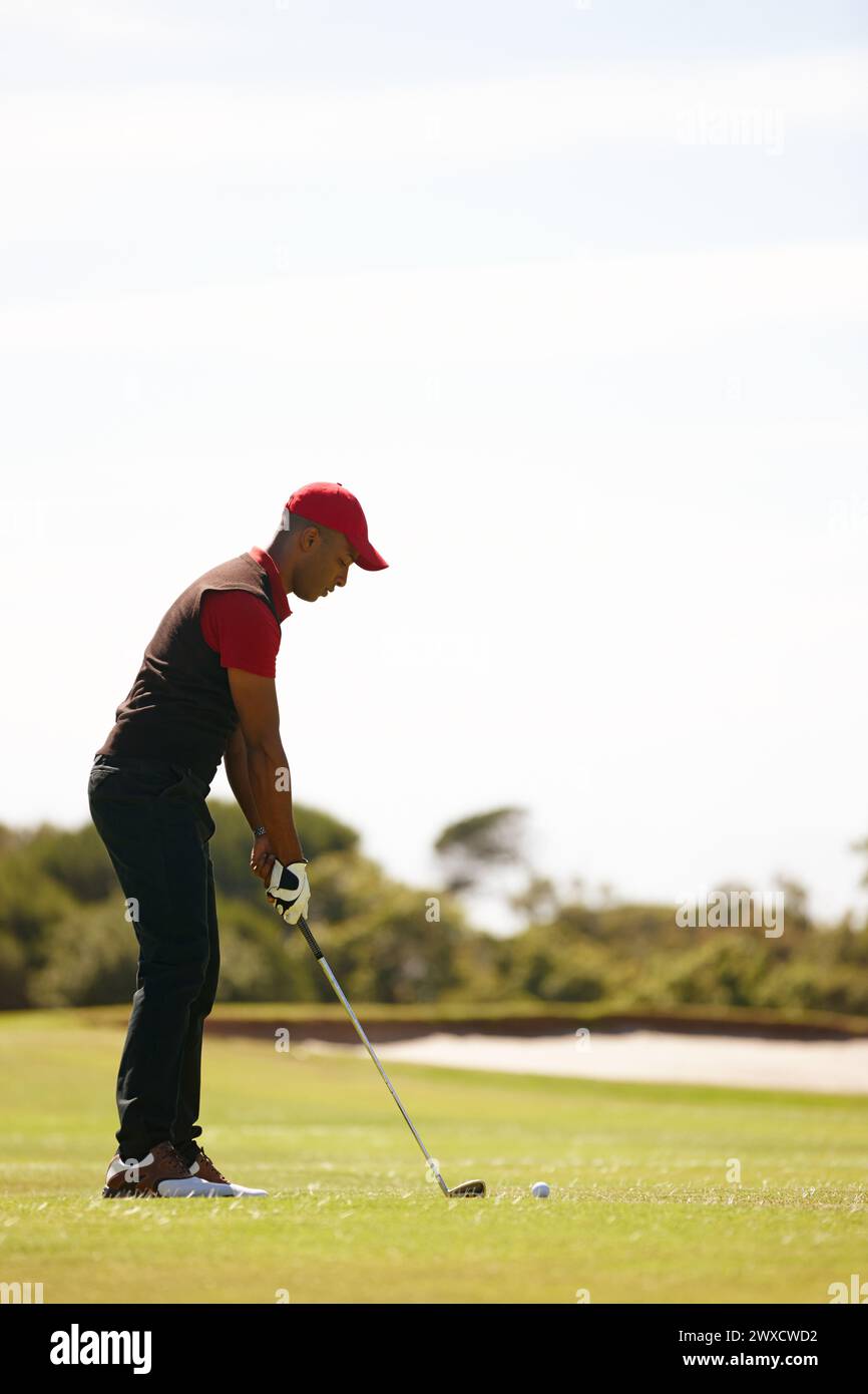 Mann, Spiel und Golfplatz mit Schläger oder Ball für Schlag, Punkt oder Schlag auf dem Rasenfeld in der Natur. Männlicher Mensch, Golfer oder Sportspieler macht sich bereit Stockfoto