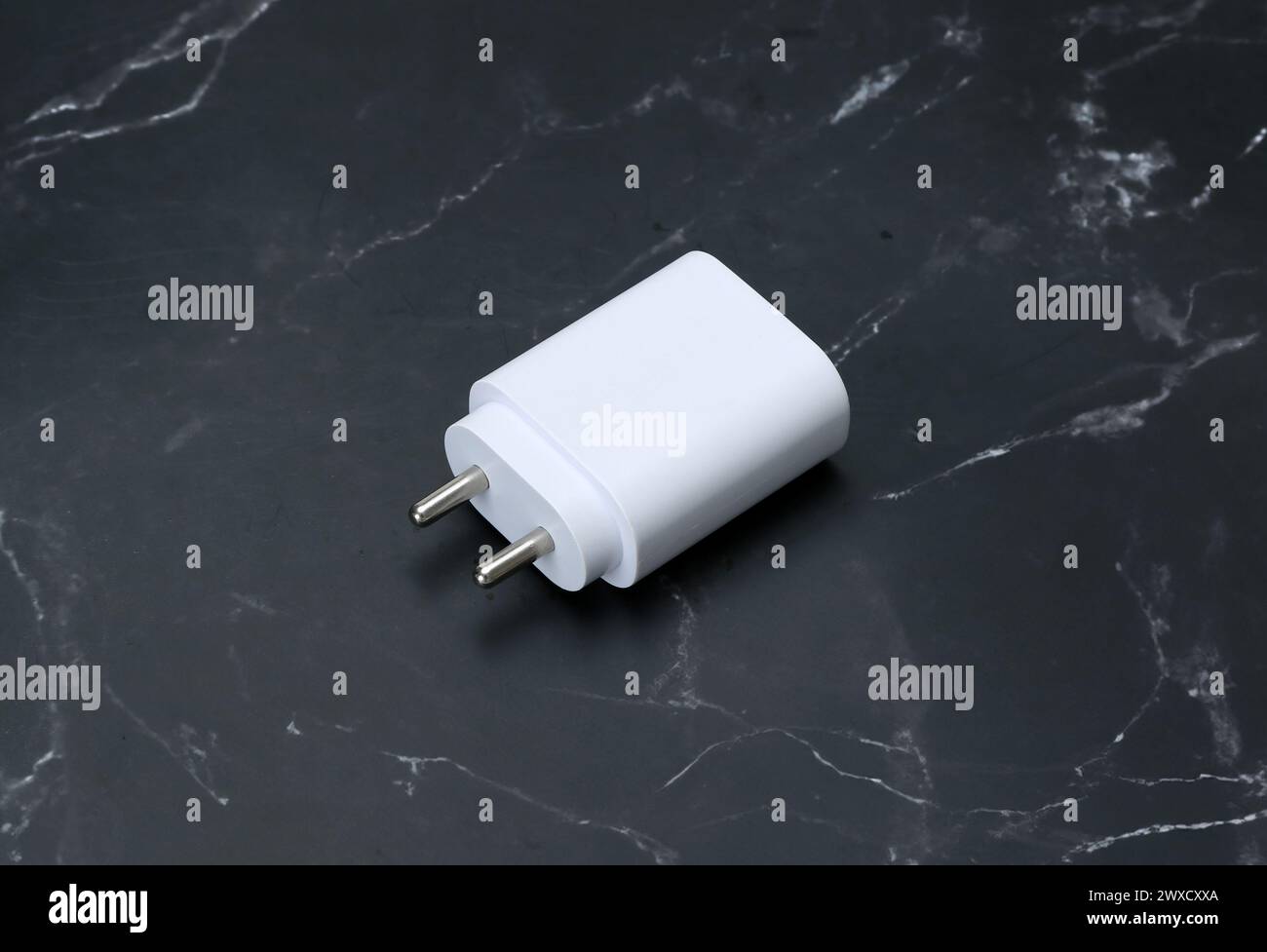 Zwei-Pin-Smatphone weiße Farbe Ladegerät isoliert auf schwarzem Marmorhintergrund Stockfoto