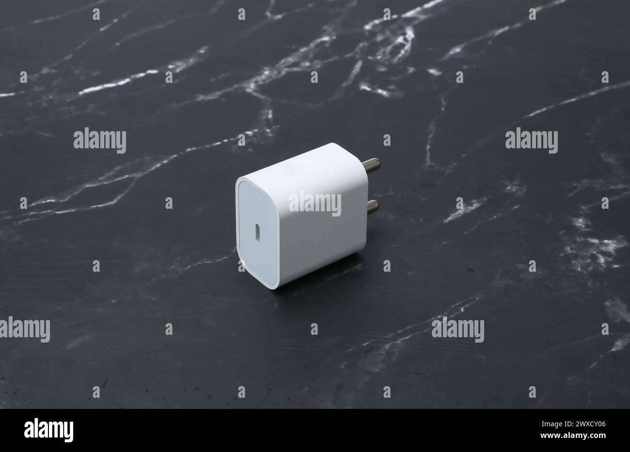 Zwei-Pin-Smatphone weiße Farbe Ladegerät isoliert auf schwarzem Marmorhintergrund Stockfoto
