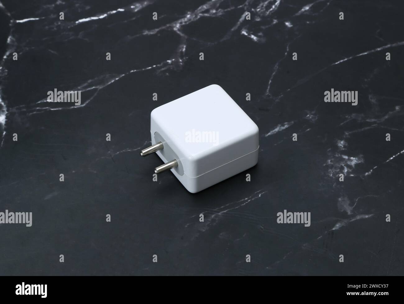 Zwei-Pin-Smatphone weiße Farbe Ladegerät isoliert auf schwarzem Marmorhintergrund Stockfoto