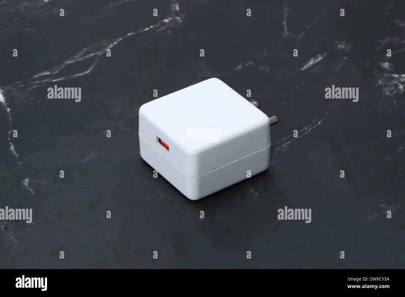 Zwei-Pin-Smatphone weiße Farbe Ladegerät isoliert auf schwarzem Marmorhintergrund Stockfoto