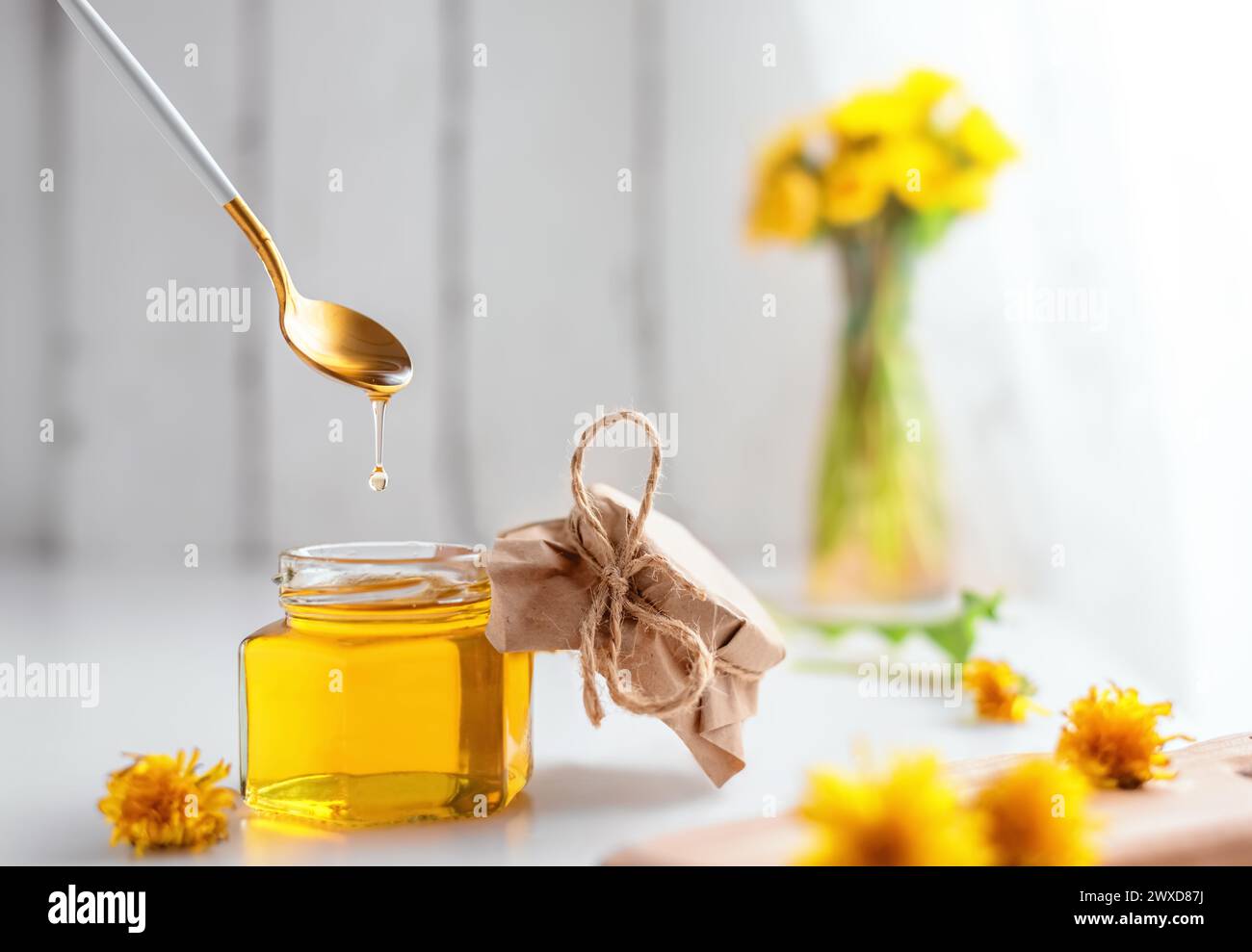 Dandelion Honig in einem Glas und frische Blumen, schöne Zusammensetzung Stockfoto