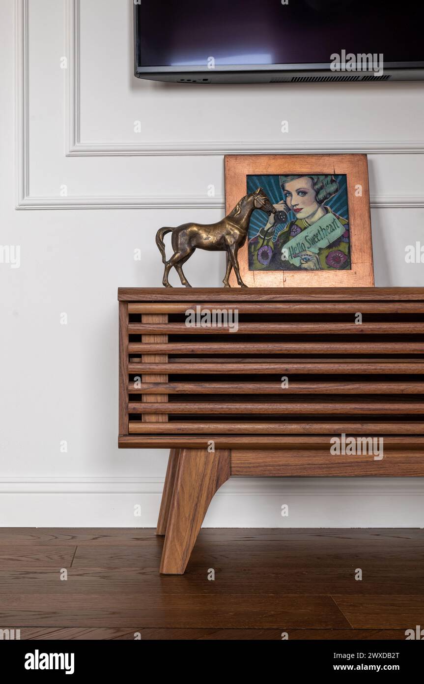 Eine Statue eines Pferdes auf einem Holztisch vor einem Fernseher Stockfoto
