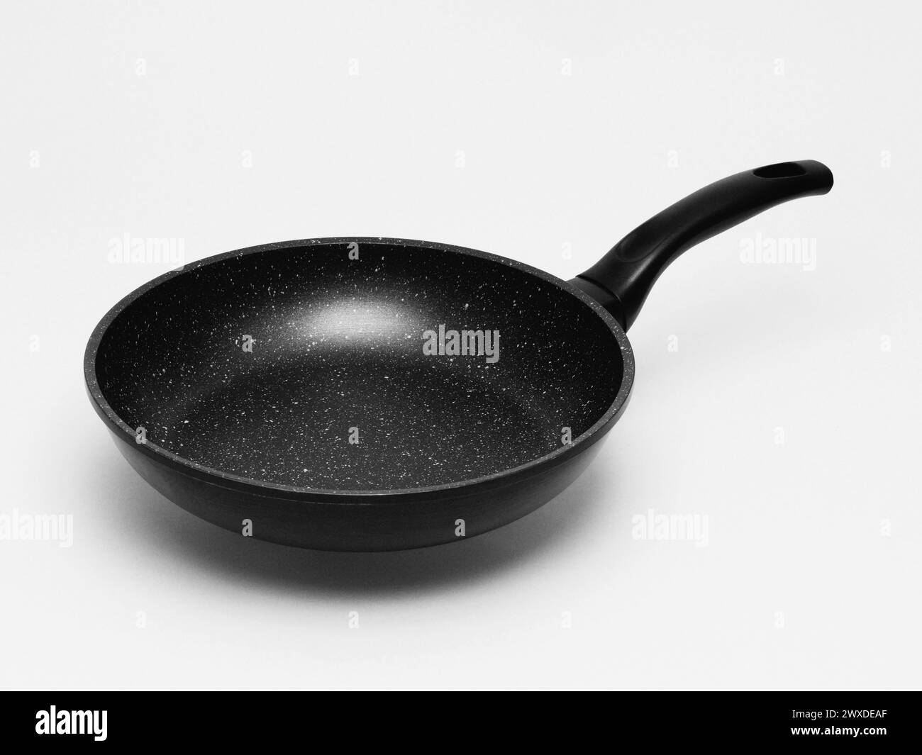 Schwarze Teflon-Pfanne auf weißem Hintergrund. Stockfoto