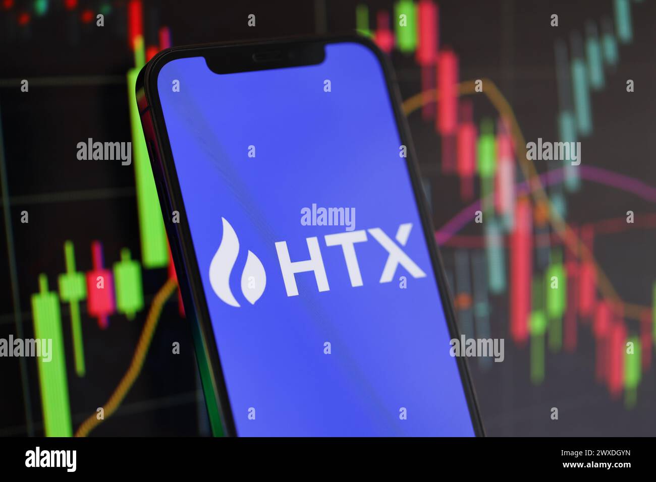 KIEW, UKRAINE - 15. MÄRZ 2024 HTX-Logo auf dem iPhone-Display und Kryptowährungswertdiagrammen. Portal für den Austausch von Kryptowährungen Stockfoto