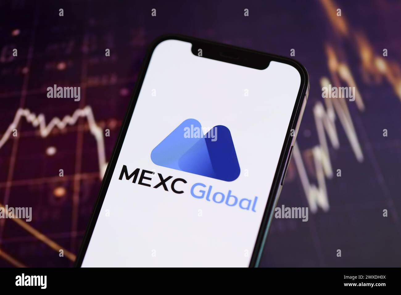 KIEW, UKRAINE - 15. MÄRZ 2024 MEXC-Logo auf dem iPhone-Display und Kryptowährungswertdiagrammen. Portal für den Austausch von Kryptowährungen Stockfoto