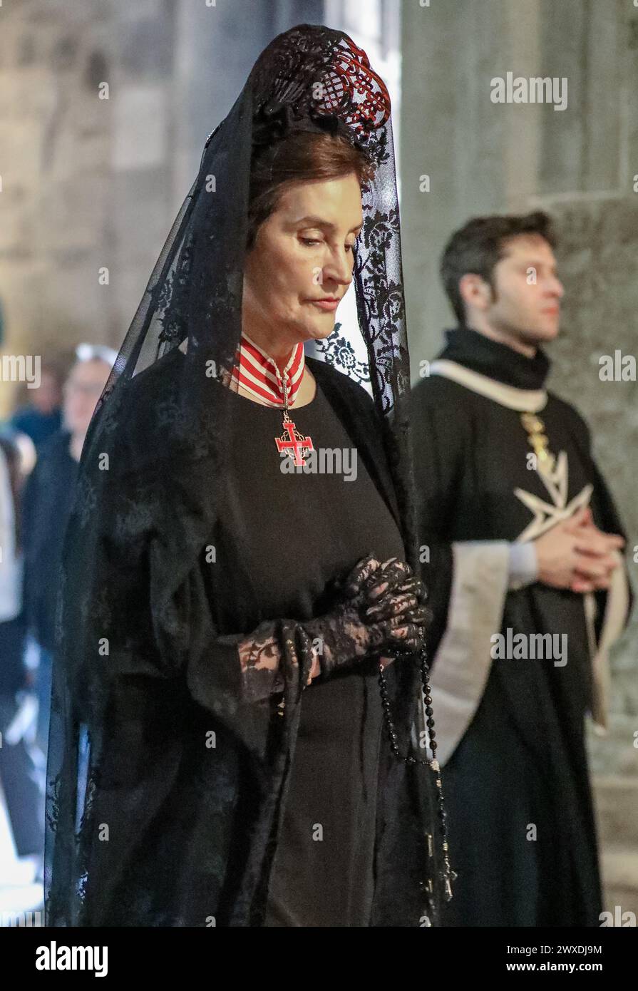 Jerusalem, Israel. 30. März 2024. Der katholische Lichtsamstag in der Grabeskirche. Eine schwarz gekleidete Priesterin tritt in die Kirche ein. Stockfoto