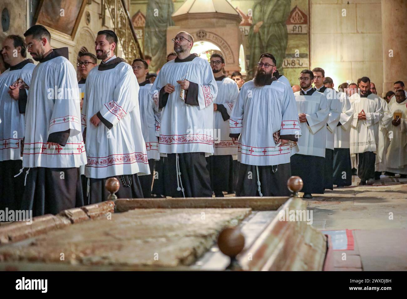 Jerusalem, Israel. 30. März 2024. Der katholische Lichtsamstag in der Grabeskirche. Mönche in weißen Mänteln marschieren in der Nähe des Stone of Sühne Credit: Yoram Biberman/Alamy Live News. Stockfoto