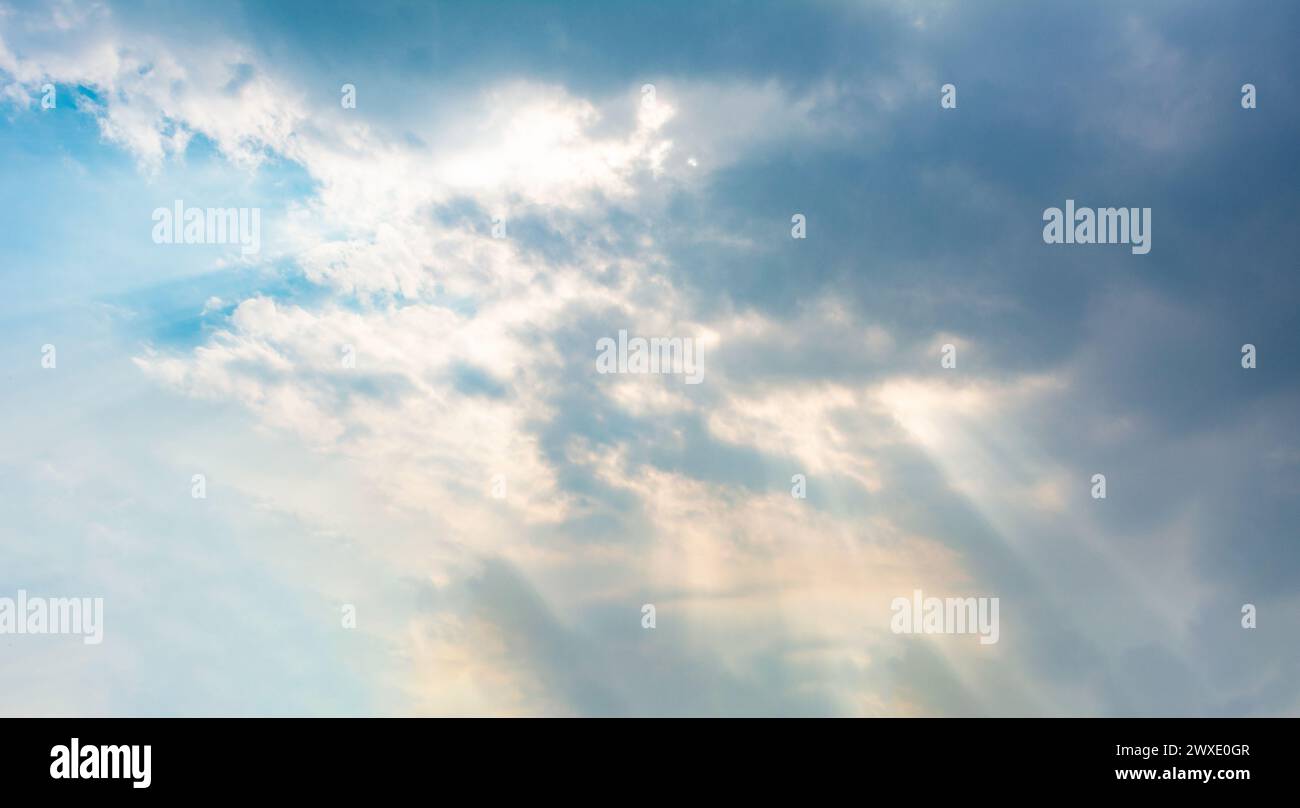 Sonnenlicht durchdringt eine Cumuluswolke. Hintergrund oder Textur des bewölkten Himmels. Stockfoto