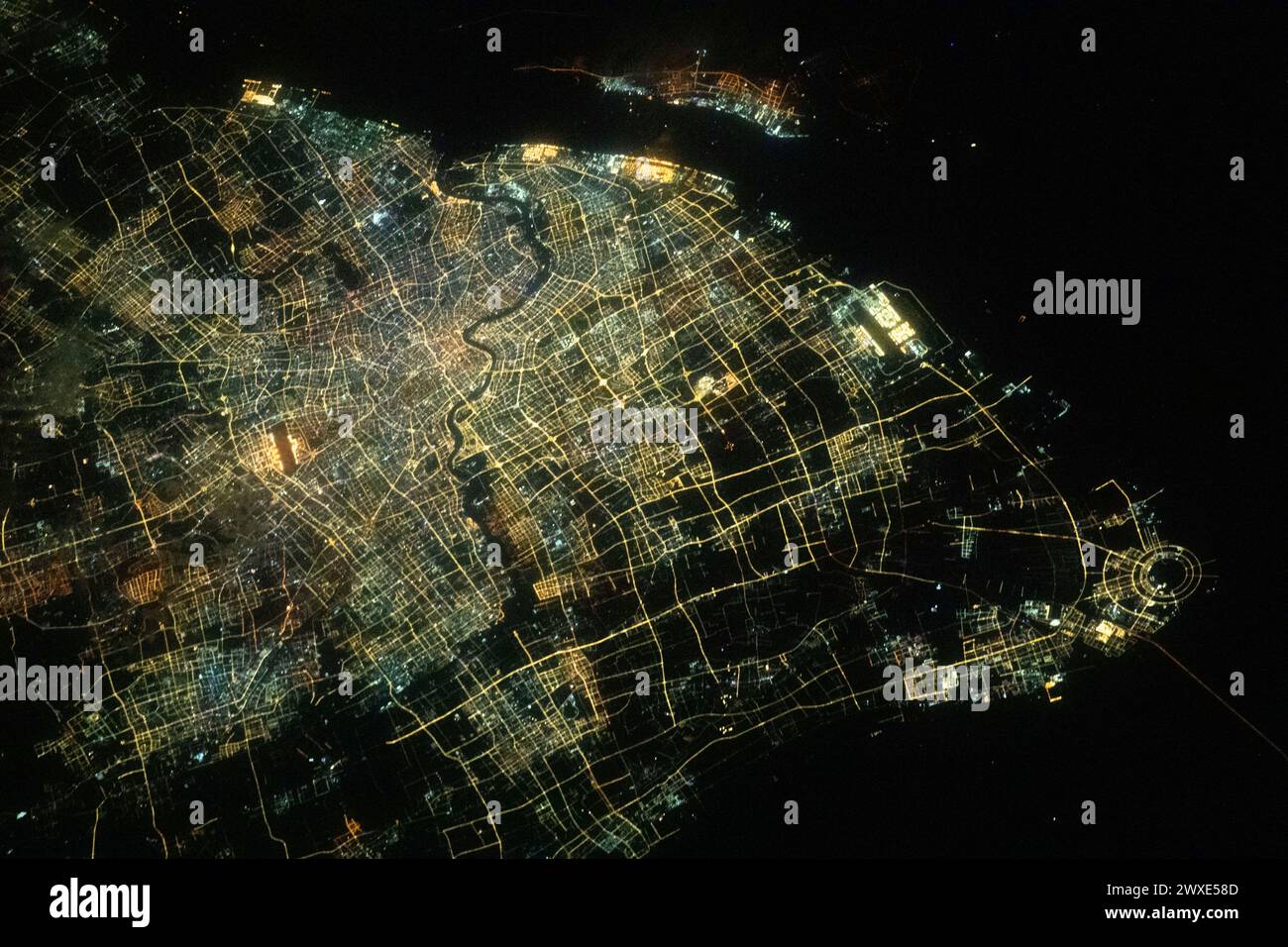 Shanghai aus dem Weltraum. Fotografiert von der Internationalen Raumstation. Die Lichter der Stadt Shanghai, der bevölkerungsreichsten Stadt Chinas mit etwa 24,9 Millionen Einwohnern, und der Fluss Huangpu, der durch die Innenstadt fließt, sind von der Internationalen Raumstation aus zu sehen, die 260 Meilen über dem Ostchinesischen Meer umkreist wurde. 17. Februar 2024 eine optimierte und verbesserte Version eines Originalbildes der NASA / obligatorischer Vermerk: NASA/J MoghbeliA Stockfoto