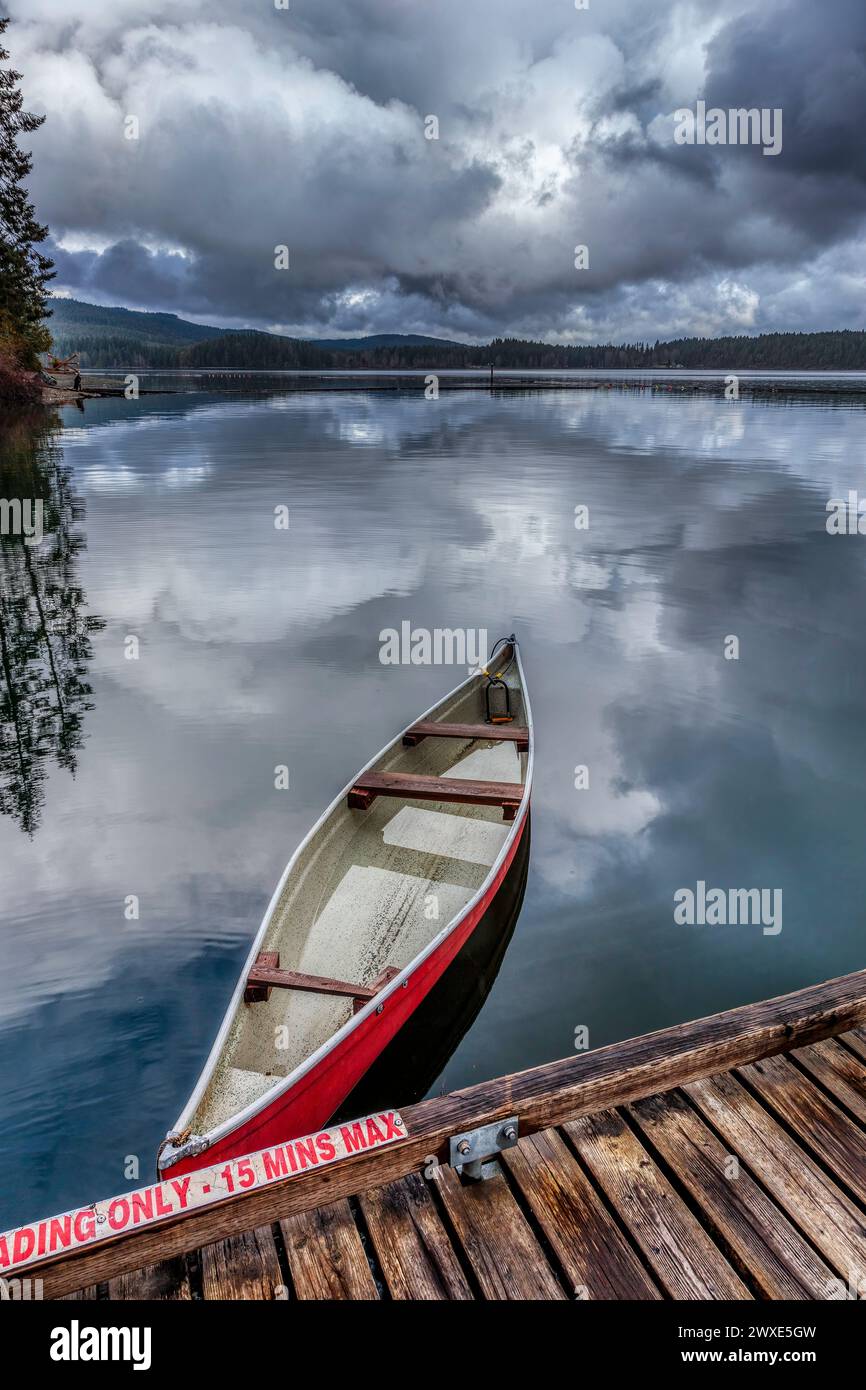 Ein Kanu am Dock neben dem Bootsanleger von Comox Lake. Comox Lake ist ein beliebter Erholungsort im Comox Valley, Vancouver Island, BC, Kanada. Stockfoto