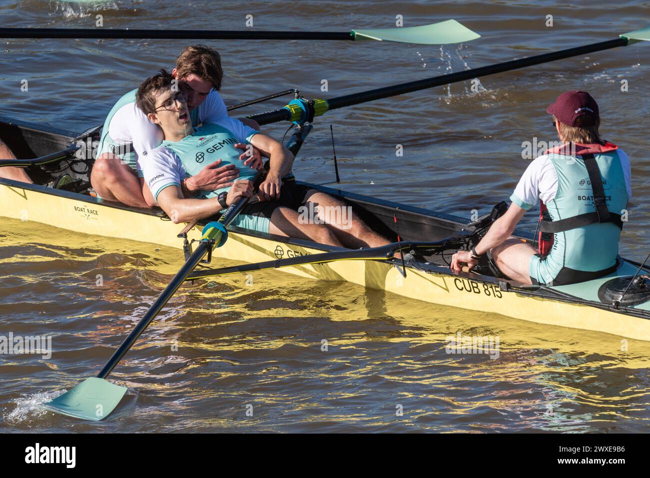 Chiswick Bridge, Chiswick, London, Großbritannien. 30. März 2024. Die Ziellinie des University Boat Race liegt kurz vor der Chiswick Bridge an der Themse. Die Veranstaltung Cambridge gegen Oxford besteht aus dem Women’s Boat Race, Women’s Reserves Race, Men’s Reserves und dem Men’s Boat Race. Die Ruderer wurden vor dem Eindringen in das Wasser aufgrund der hohen Mengen von E. coli-Bakterien gewarnt. Cambridge gewann sowohl die Herren- als auch die Frauen-Veranstaltung. Herren-Rennen. Der Cambridge Stroke Ruderer Matt Edge leidet nach der Ziellinie unter Ermüdung, unterstützt von Luca Ferraro Stockfoto