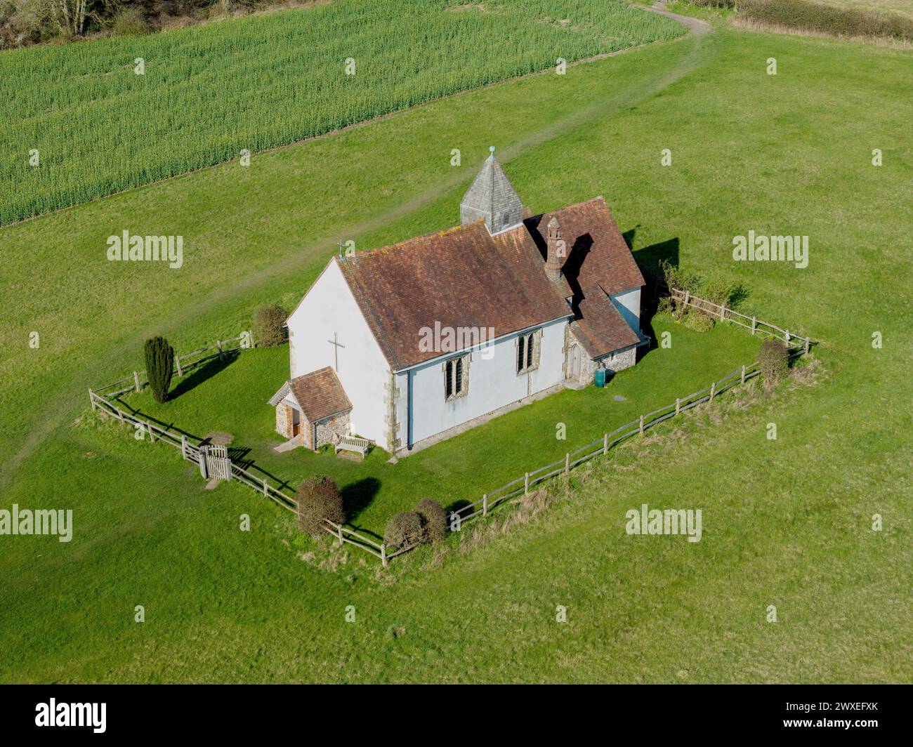 St. Huberts die Kirche auf dem Hügel von oben. Sonniger Frühlingstag in Idsworth Hampshire. Blick nach unten zum Vordereingang und zur rechten Seite. Stockfoto