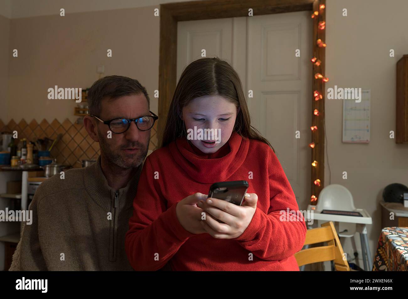 Mädchen, 10 Jahre, Handy, Vater beobachtet, Mecklenurg-Vorpommern, Deutschland Stockfoto