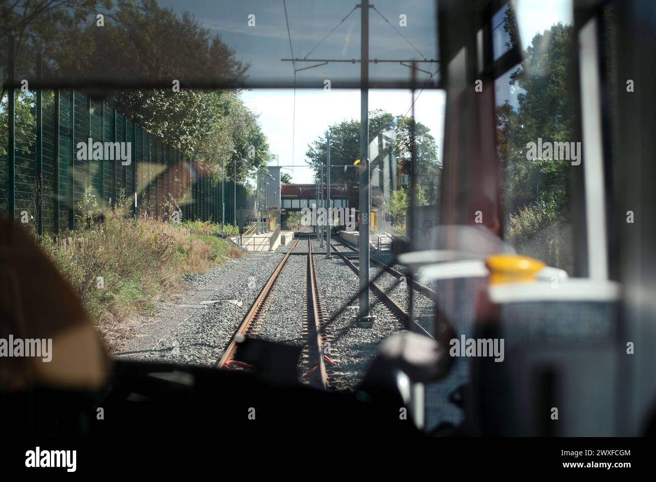 Blick von der Vorderseite einer Straßenbahn aus Manchester, die sich der Haltestelle West Didsbury Metrolink auf der Palatine Road nähert. Stockfoto