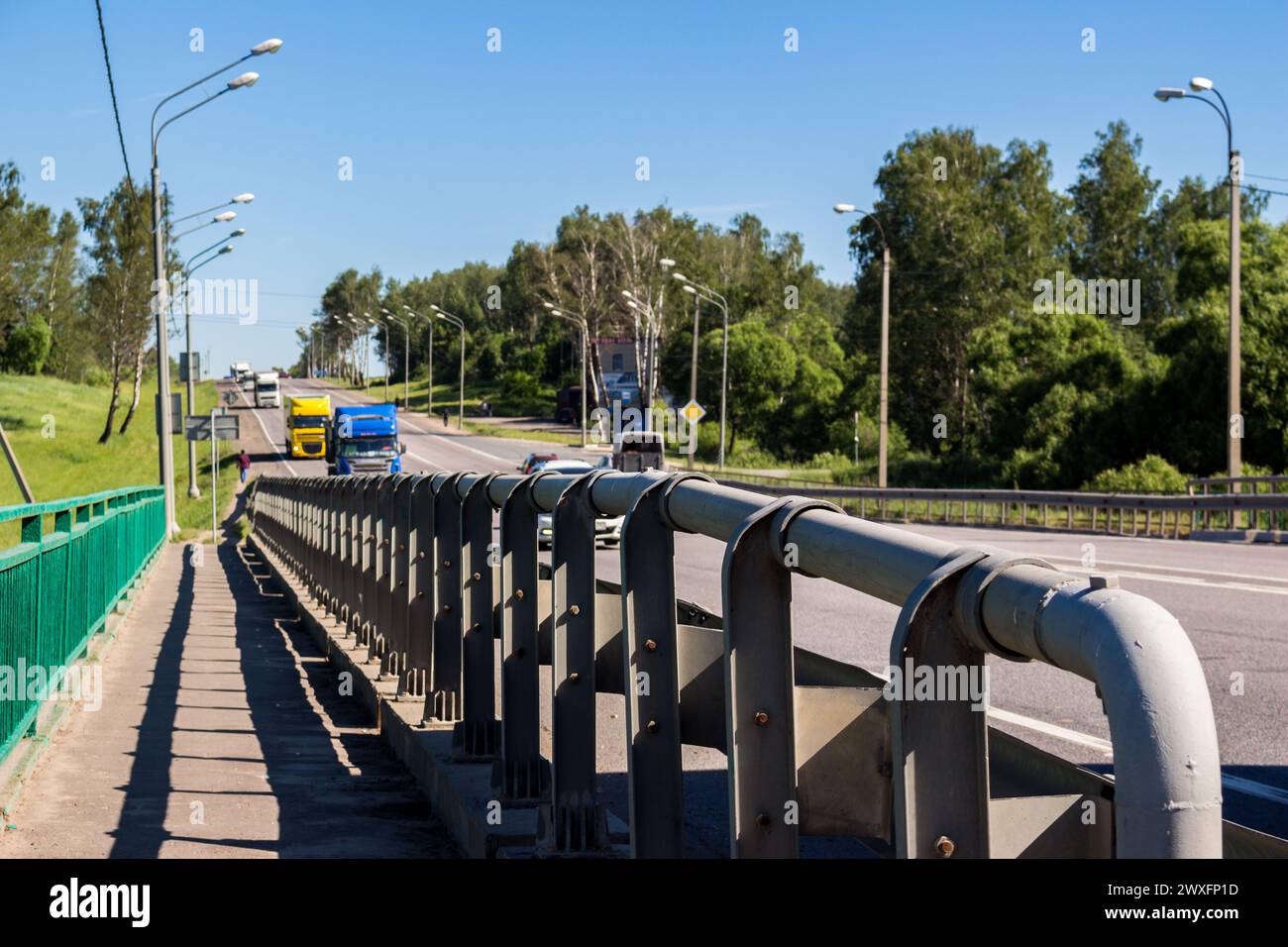 Typ eines Straßenrändes mit einem Metall-Anschlagpunkt und einer Autobahn mit Lkw Stockfoto