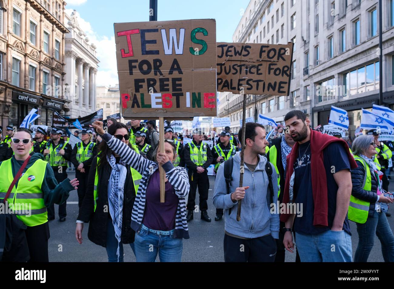 London, UK, 30. März 2024. Zwei pro-palästinensische jüdische Demonstranten stehen vor der israelischen Gegendemonstration entlang der Route des elften nationalen palästinensischen marsches. Die Gruppe trug die Nationalflagge und entführte Plakate, als sie die Freilassung von Geiseln forderten, die noch immer in Gaza festgehalten wurden. Quelle: Eleventh Photography/Alamy Live News Stockfoto