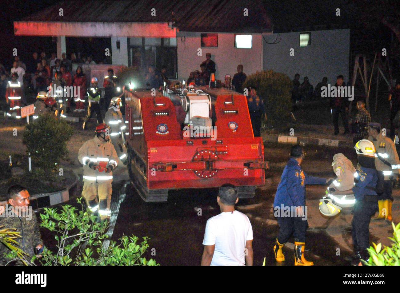 (240331) -- BOGOR, 31. März 2024 (Xinhua) -- Ein Feuerwehrfahrzeug bereitet sich auf die Arbeit an der Explosionsstelle in Bogor, West Java, Indonesien, vor, 31. März 2024. Mehr als 130 Familien wurden nach einer Explosion in einem militärischen Munitionslager in der Nähe der indonesischen Hauptstadt Jakarta am Samstagabend evakuiert, sagte ein Beamter am Sonntag.die Explosion ereignete sich in dem Lager, das dem Regionalkommando Jayakarta gehört, im Dorf Ciangsana, im Regierungsbezirk Bogor in der Provinz West Java. etwa 7 km von Jakartas östlicher Grenze entfernt. Berichten zufolge war die Explosion innerhalb eines 7 km langen Rades zu hören Stockfoto