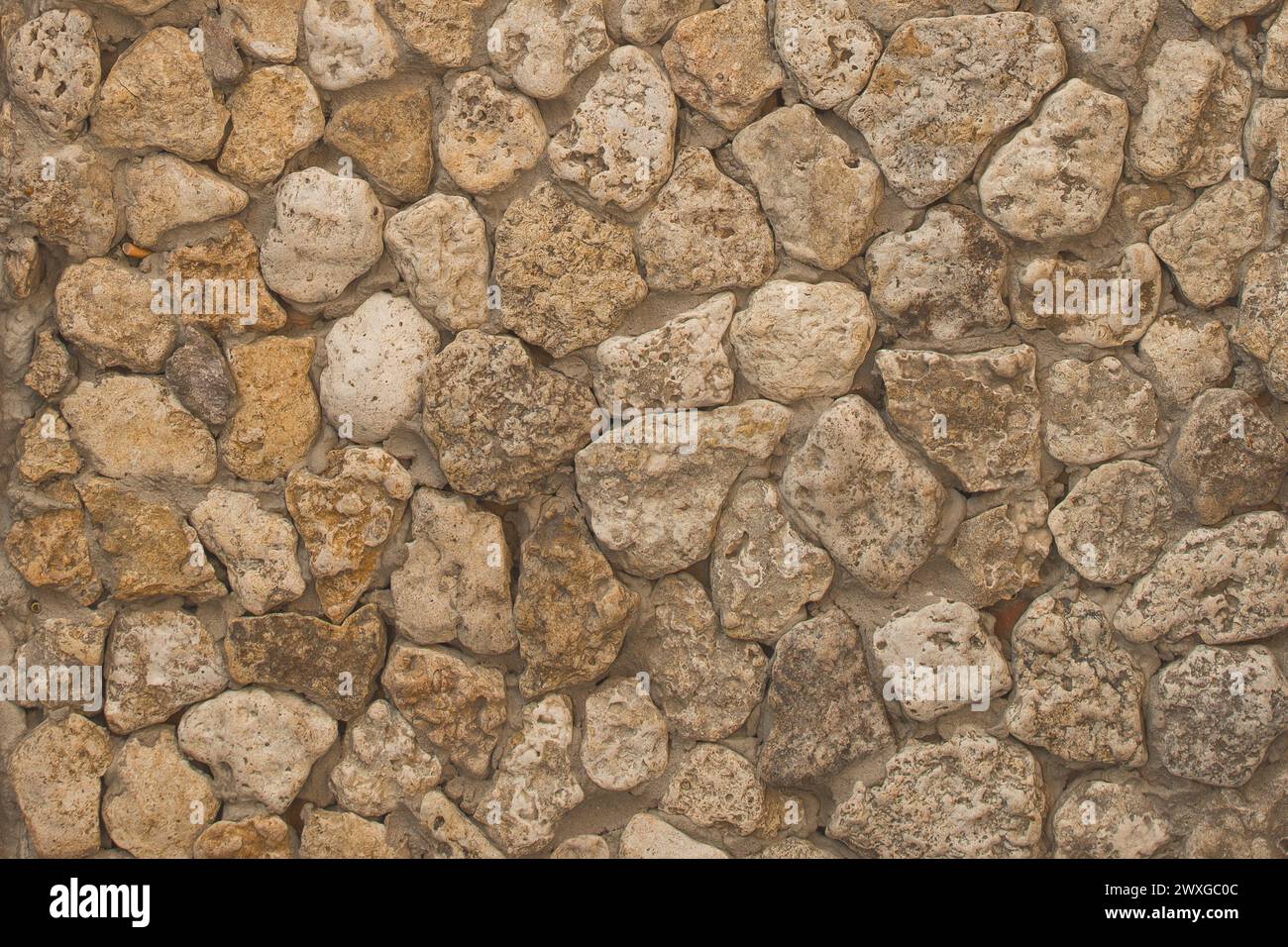 Braune raue Steinbodenwand abstrakte Muster Mosaikstruktur Hintergrundstruktur Fliesen massiver Felsen. Stockfoto