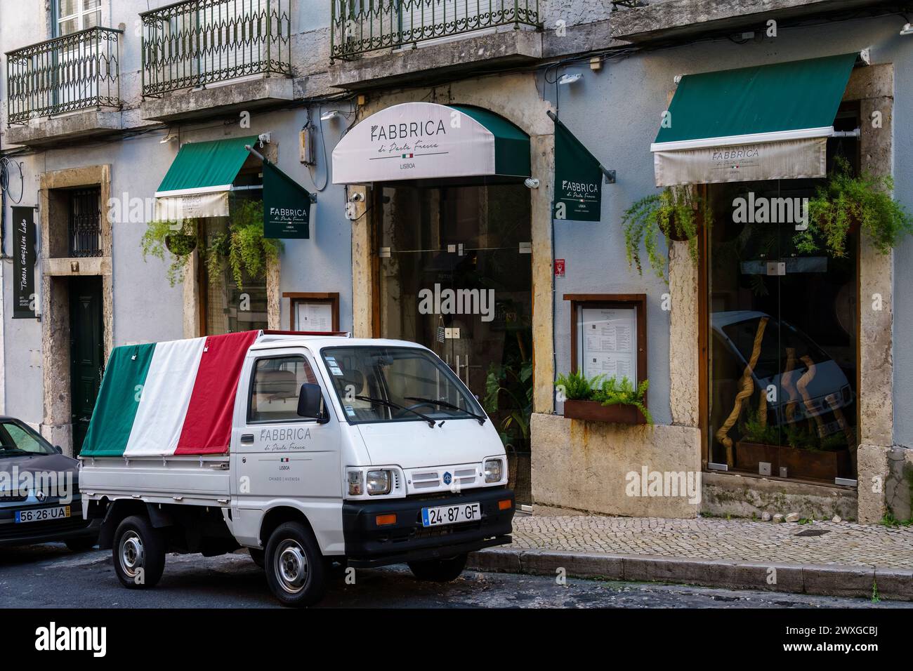 Weißer Truck mit italienischer Flagge parkt vor dem Restaurant Fabbrica Di Pasta Fresca. Lissabon, Portugal. Februar 2024. Stockfoto