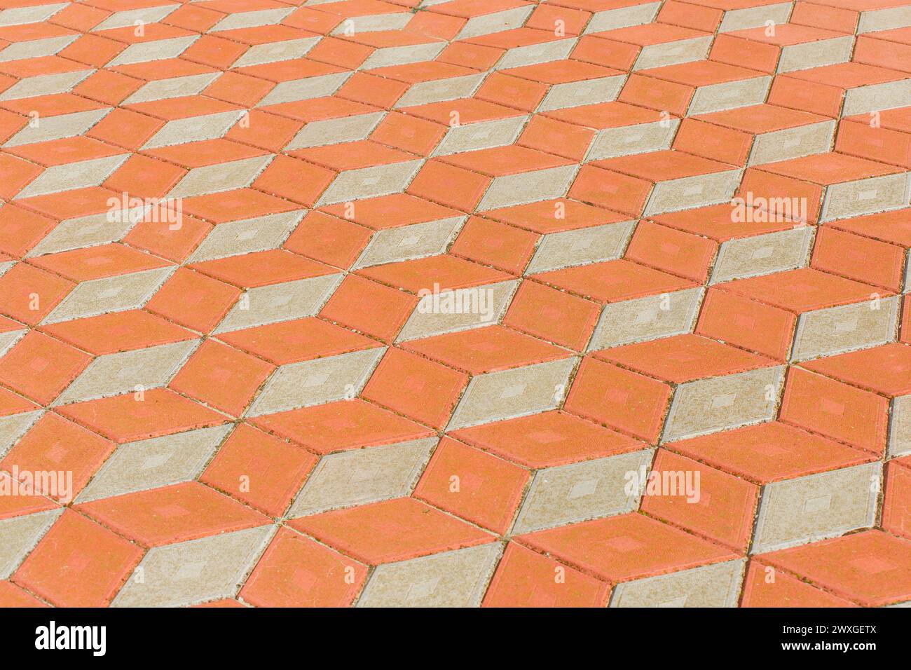 Abstraktes Muster von orange und hellen Pflasterfliesen Straßenoberfläche Stadttextur Hintergrund. Stockfoto