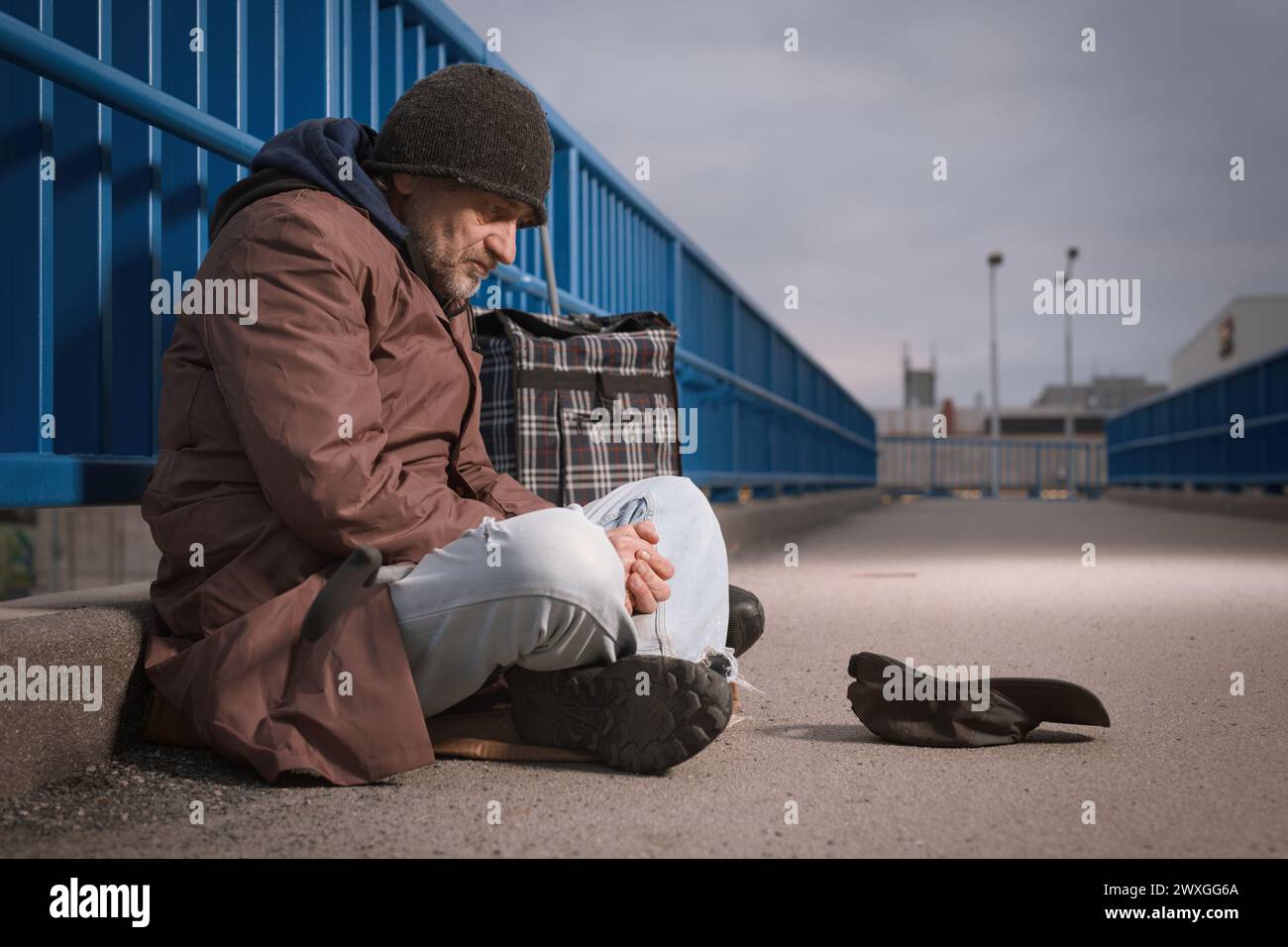 Seniorenbetteler auf der Stadtüberführung und bettelt um etwas Geld Stockfoto