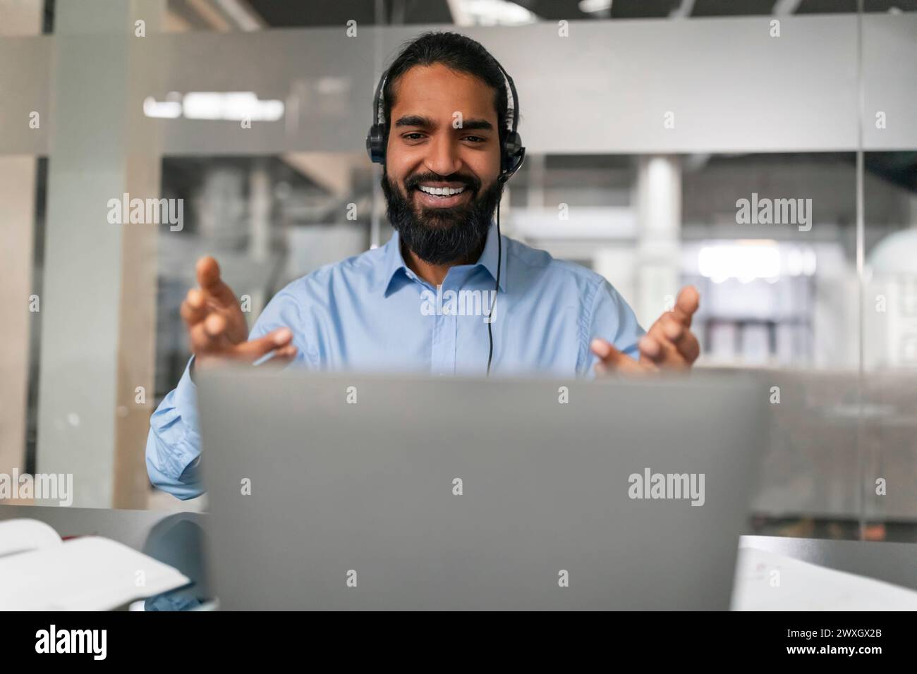 Lächelnder Mann, der in Videogesprächen Gesten gibt Stockfoto
