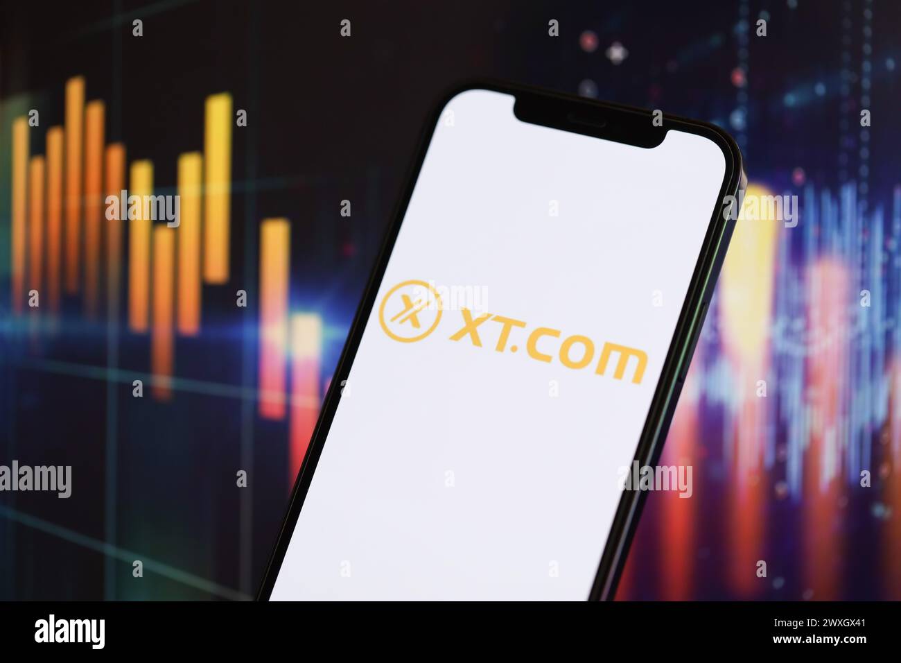KIEW, UKRAINE - 15. MÄRZ 2024 XTcom-Logo auf dem iPhone-Display und Kryptowährungswertdiagrammen. Portal für den Austausch von Kryptowährungen Stockfoto