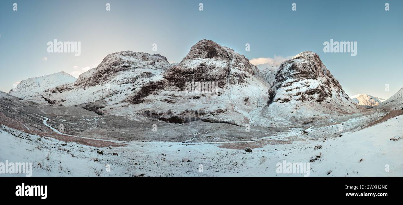 Ein Panoramablick auf die drei Schwestern Berge in Glencoe, bedeckt mit Schnee an einem sonnigen Tag. Schottische Highlands. Stockfoto