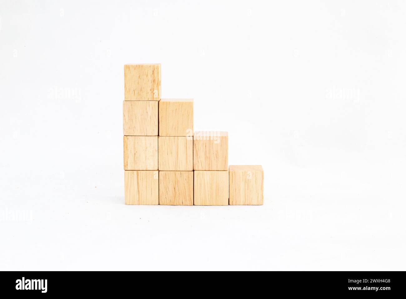 Gestapelte Holzwürfel bilden eine ansteigende Treppe nach links, isoliert auf weißem Hintergrund. Leerer Cubes Platz für Text. Stockfoto