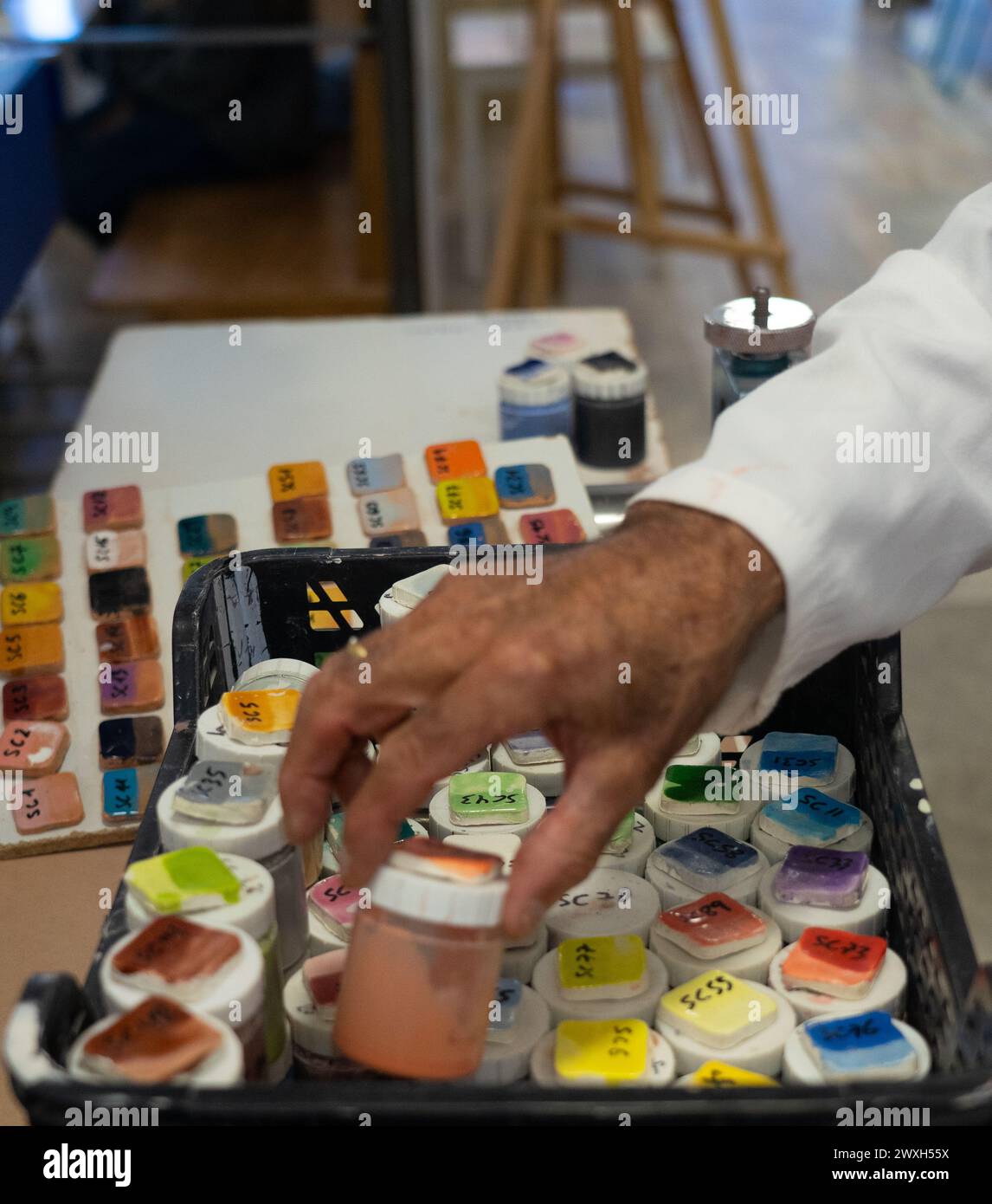 Die Hand eines älteren Mannes pflückt eine Keramikglasur in einer Art Keramik Stockfoto