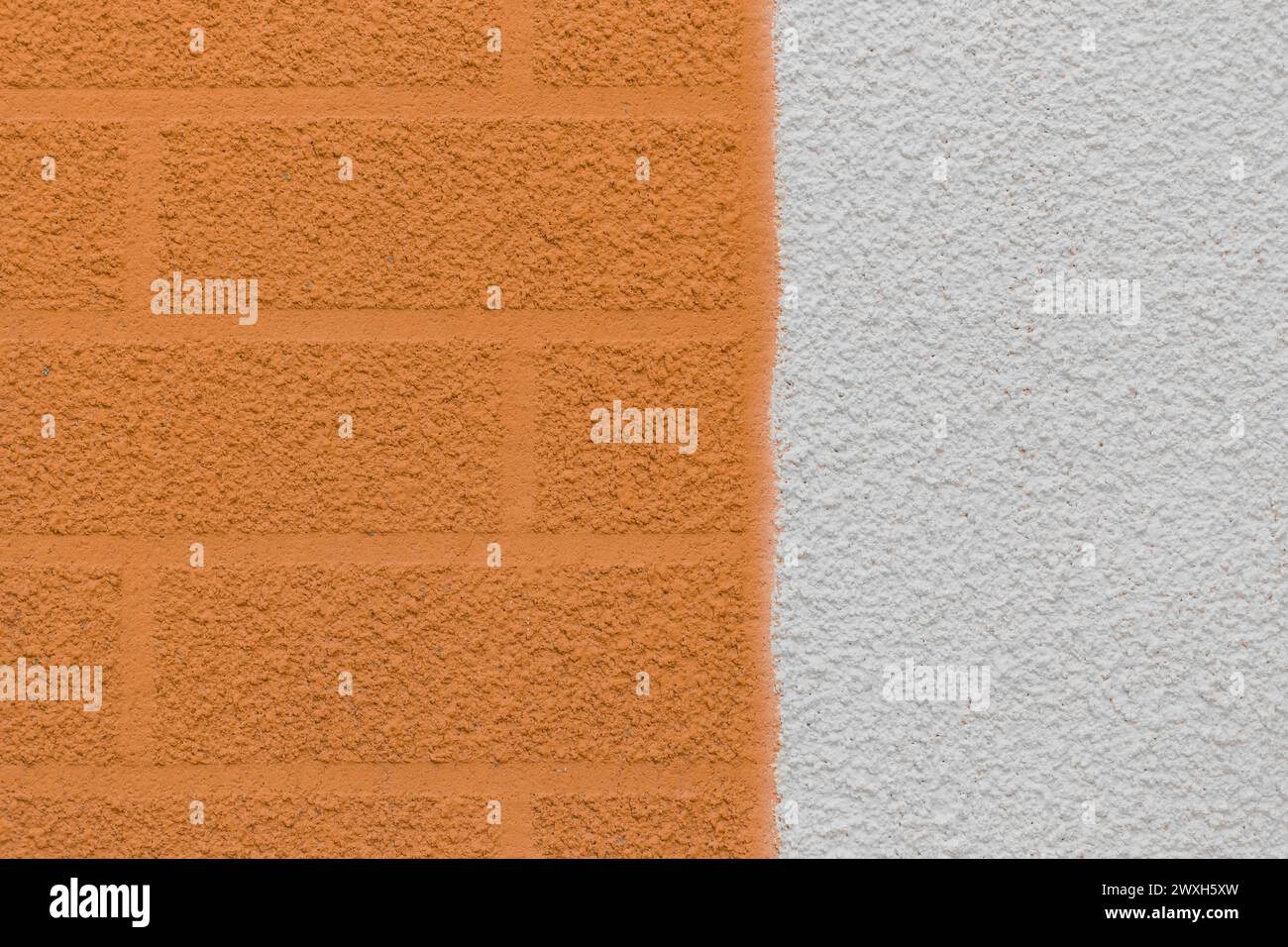 Braune Putzwand in zwei Farben mit abstraktem Ziegelmuster und weißer Stuckhintergrundstruktur. Stockfoto