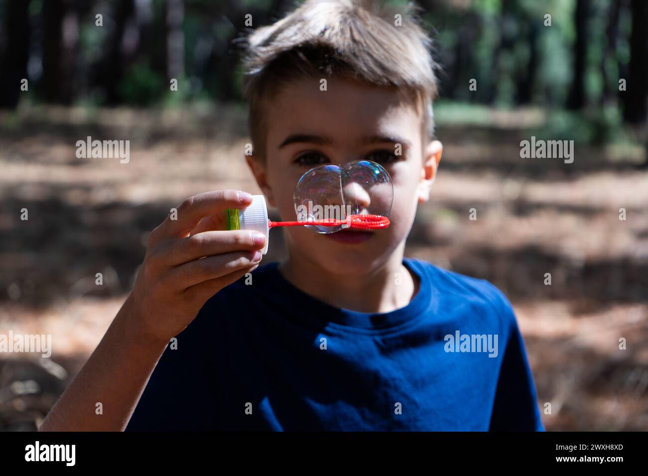 Kind spielt mit Seifenblasen Stockfoto