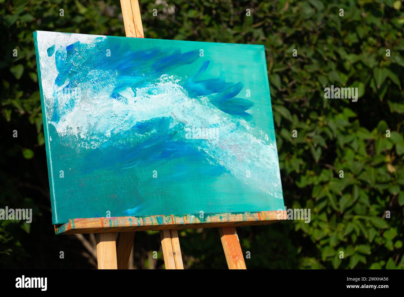 Abstrakte Kunstmalerei auf einer Staffelei mit Naturhintergrund Stockfoto