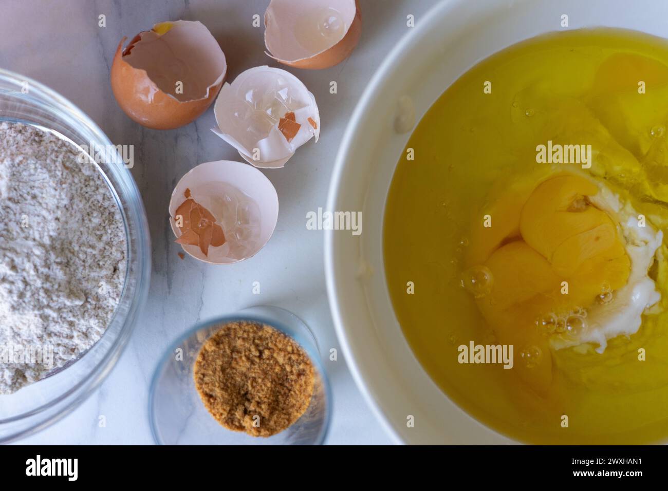 Schüssel mit Zutaten, um einen Biskuitkuchen zu machen Stockfoto